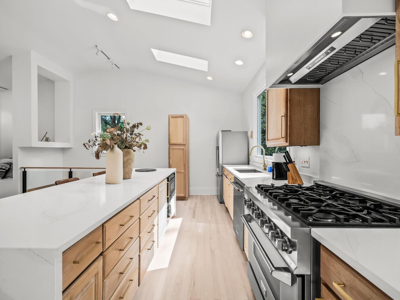 300 Dartmouth Road Raleigh, NC 27609 - Photo 9 of 28 a kitchen with sink a stove and wooden cabinets
