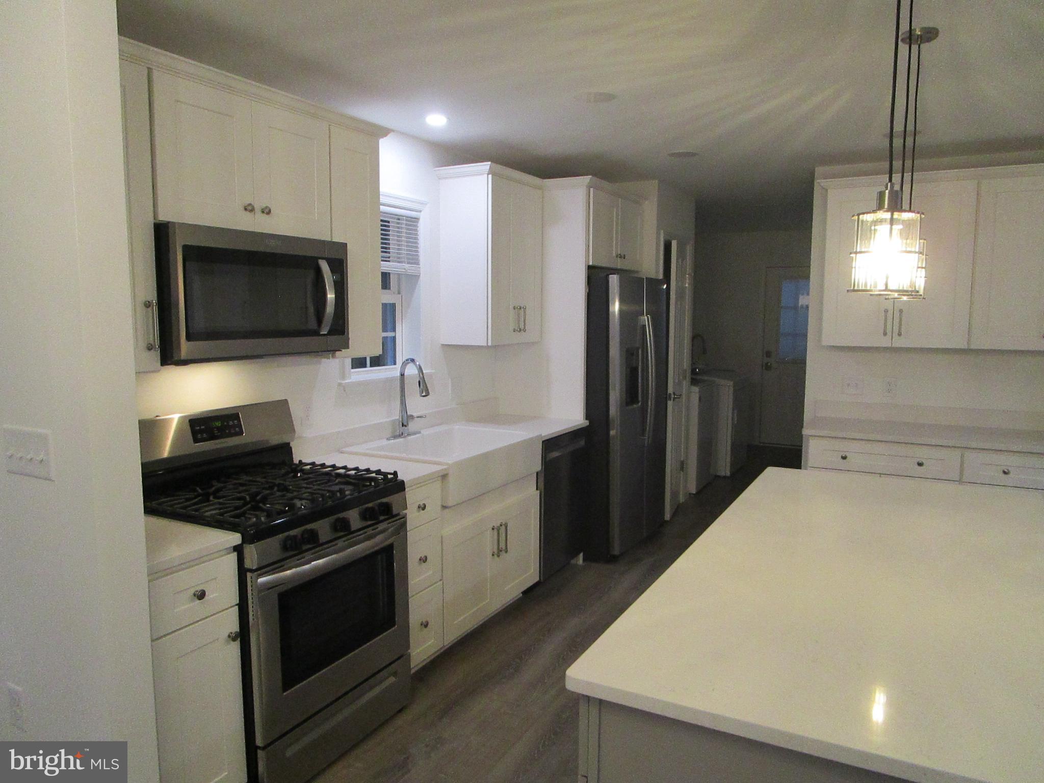 32 Tiffany Drive Rehoboth Beach, DE 19971 - Photo 18 of 43 a kitchen with stainless steel appliances a stove microwave and refrigerator