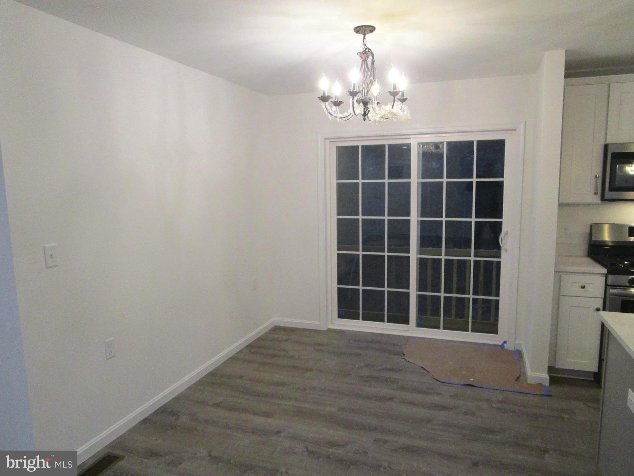 32 Tiffany Drive Rehoboth Beach, DE 19971 - Photo 20 of 43 a view of empty room with windows and wooden floor