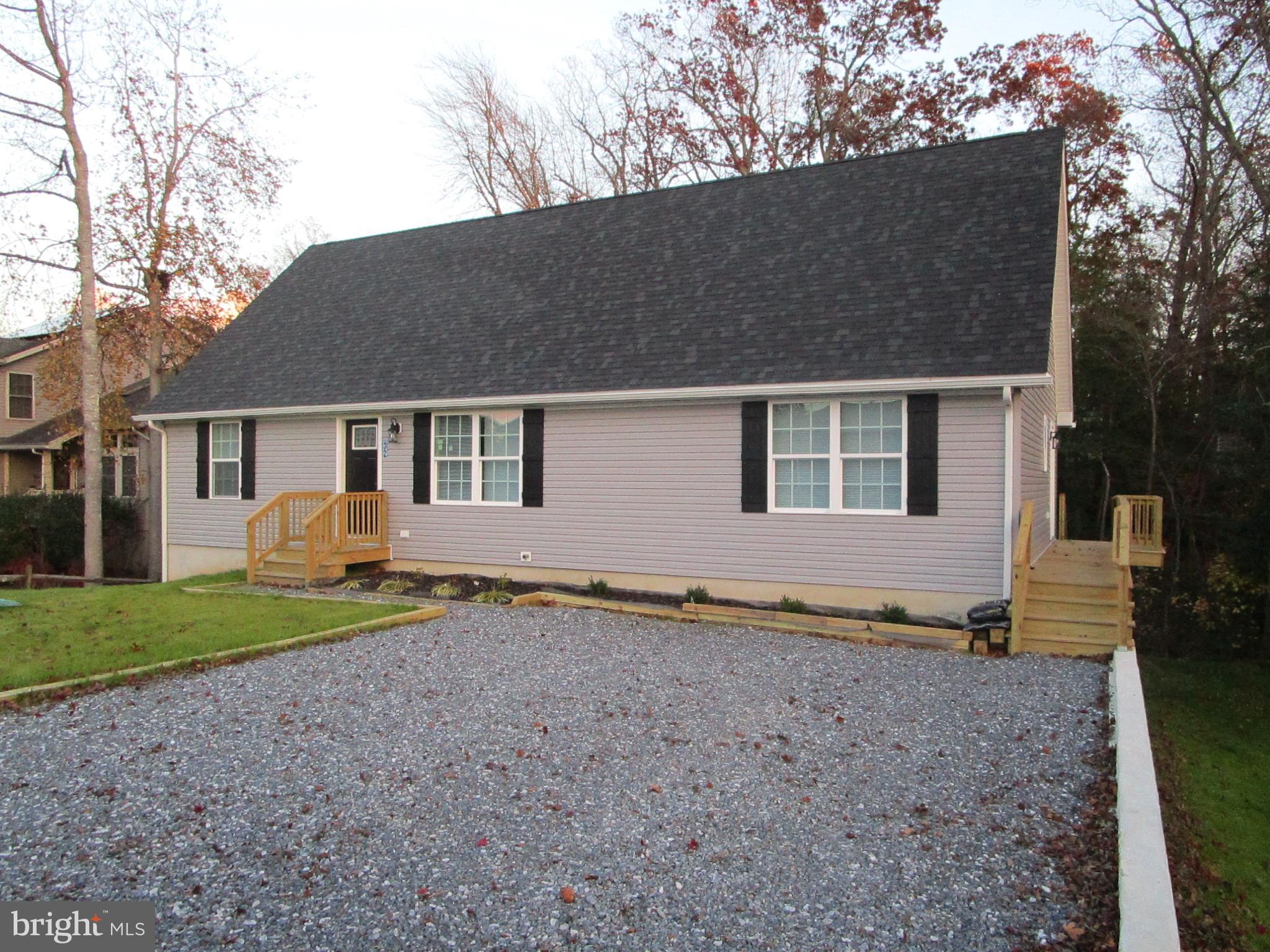 32 Tiffany Drive Rehoboth Beach, DE 19971 - Photo 3 of 43 a house that has a lot of plants and trees in it