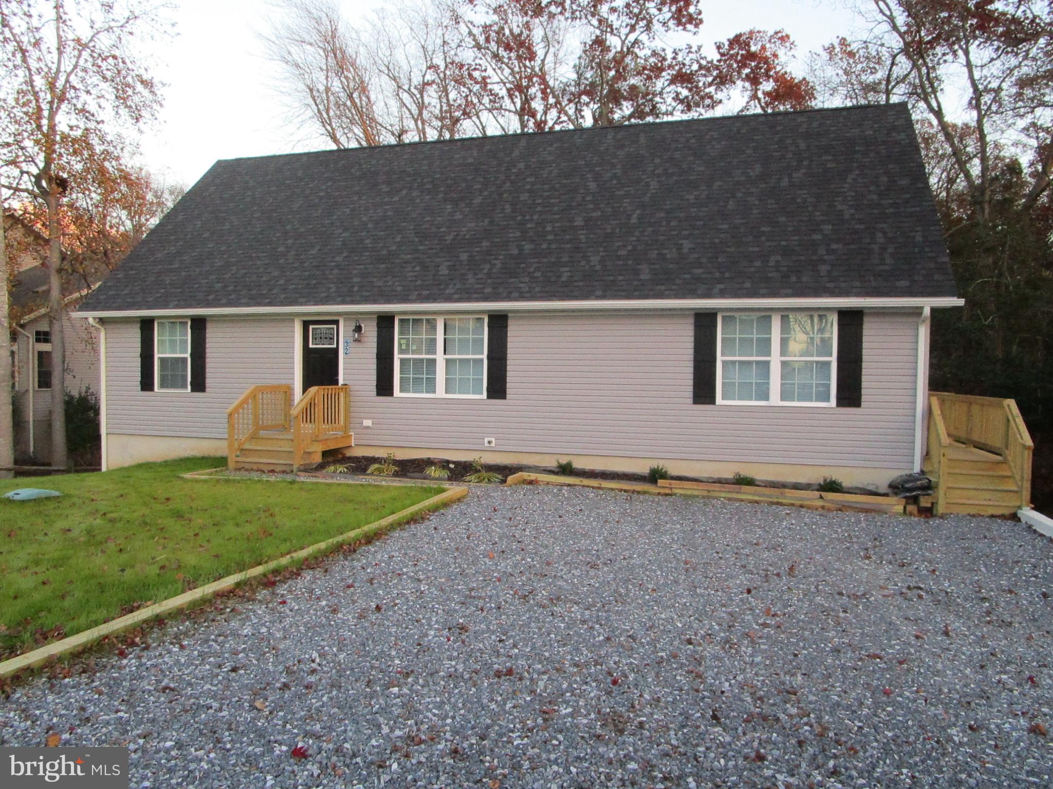 32 Tiffany Drive Rehoboth Beach, DE 19971 - Photo 4 of 43 a backyard of a house with barbeque oven and wooden fence