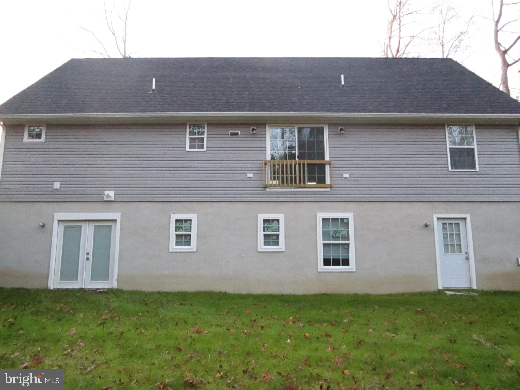 32 Tiffany Drive Rehoboth Beach, DE 19971 - Photo 5 of 43 a brick house that has a lots of windows in it