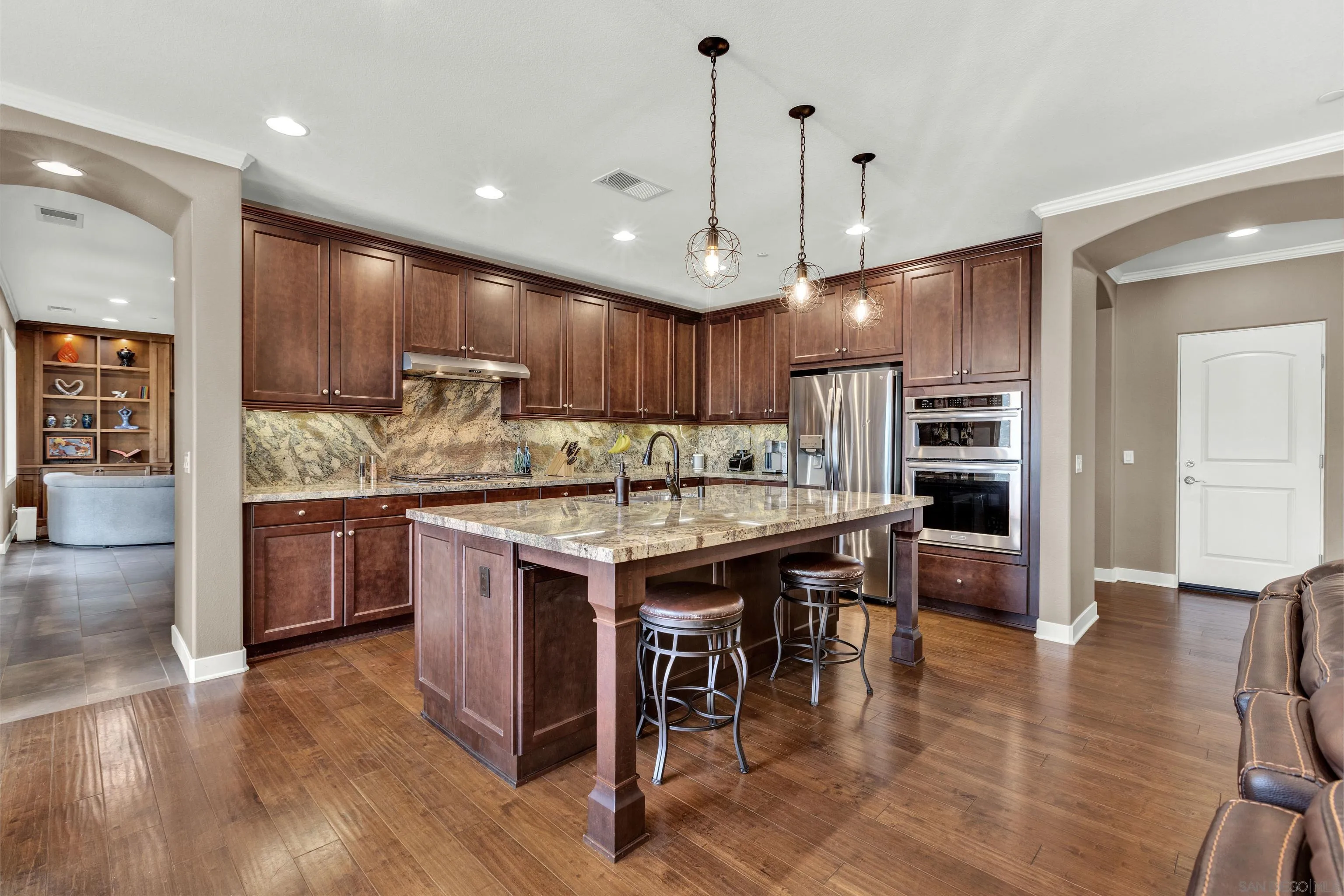 12884 Vineyard Crest Place Lakeside, CA 92040 - Photo 26 of 53 a kitchen with kitchen island granite countertop wooden floors cabinets a counter and appliances
