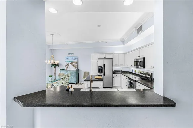 a kitchen with kitchen island a counter top a stove and a sink