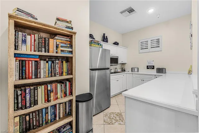 a kitchen with a refrigerator and a book shelf