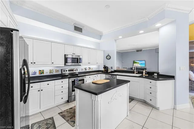 a kitchen with granite countertop white cabinets and white appliances