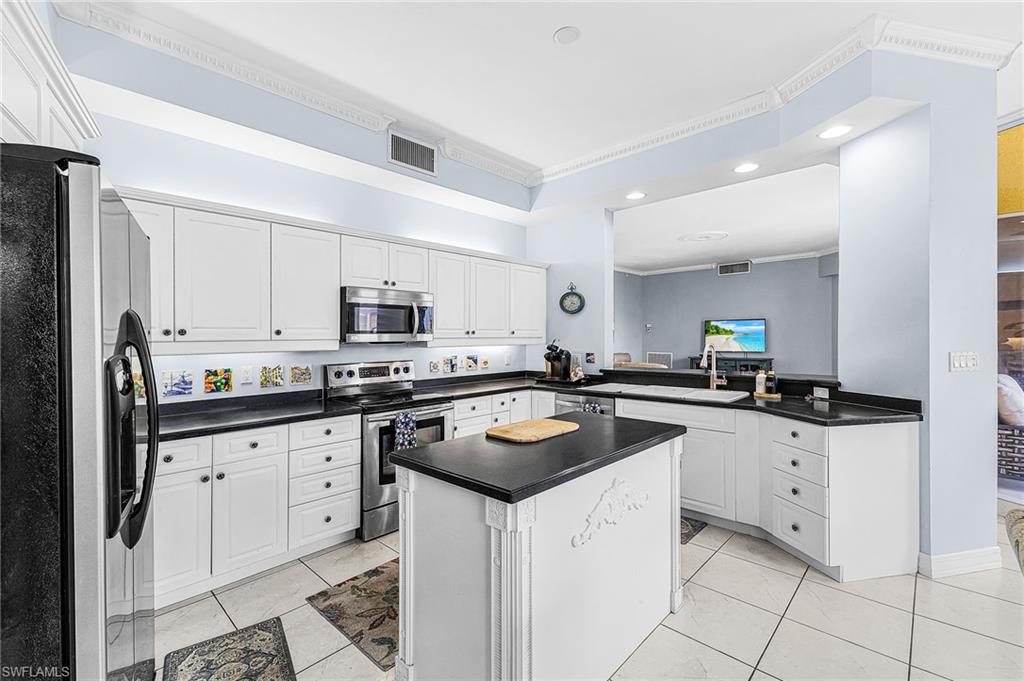 451 Bayfront Place, Unit 5503 Naples, FL 34102 - Photo 6 of 22 a kitchen with granite countertop white cabinets and white appliances
