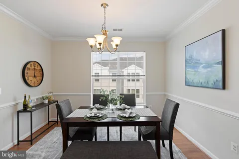 a view of a dining room with furniture a chandelier and wooden floor