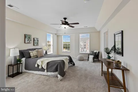 a spacious bedroom with a bed a couch and a chandelier