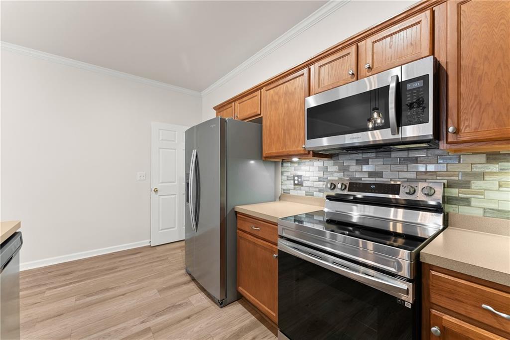 119 Holiday Road, Unit 603 Buford, GA 30518 - Photo 15 of 34 a kitchen with stainless steel appliances granite countertop a stove microwave and refrigerator