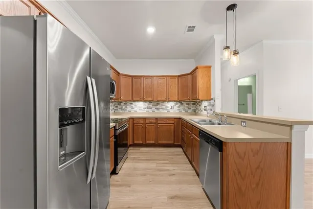 a kitchen with stainless steel appliances granite countertop a refrigerator a sink and a stove