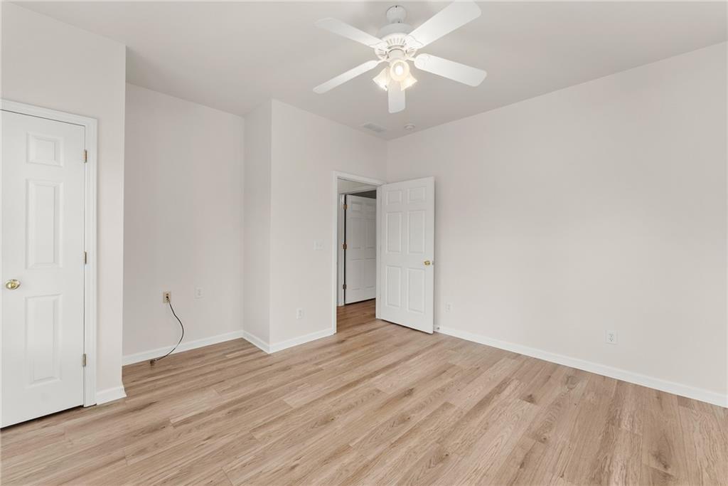119 Holiday Road, Unit 603 Buford, GA 30518 - Photo 22 of 34 an empty room with wooden floor and ceiling fan