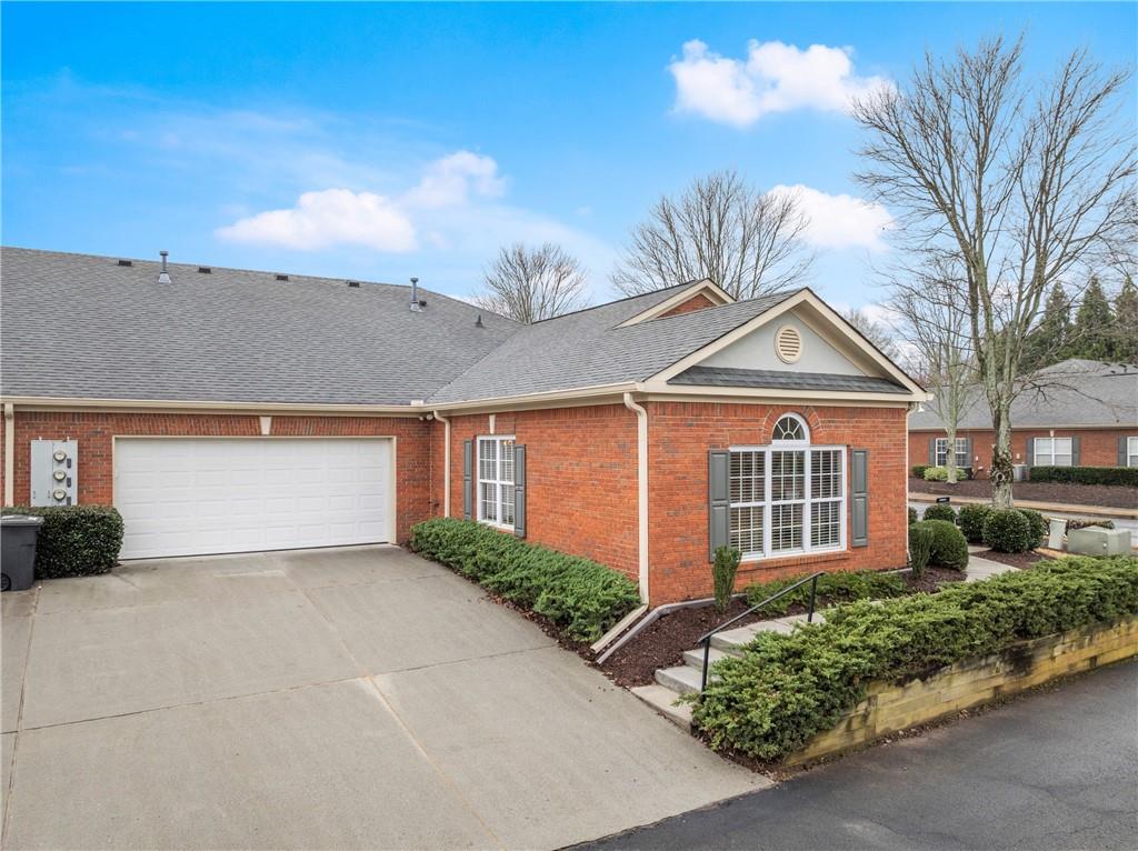 119 Holiday Road, Unit 603 Buford, GA 30518 - Photo 4 of 34 a front view of a house with a yard and garage