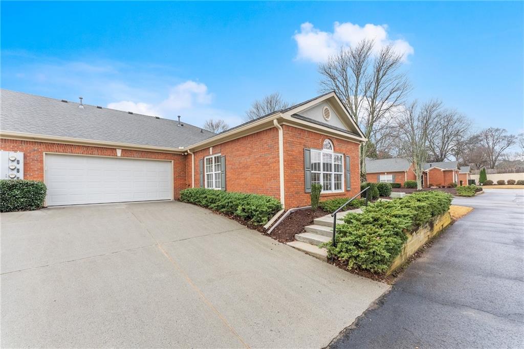 119 Holiday Road, Unit 603 Buford, GA 30518 - Photo 7 of 34 a front view of a house with a yard and potted plants