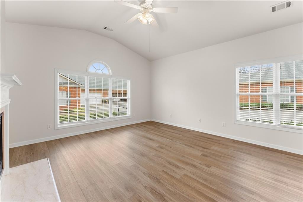 119 Holiday Road, Unit 603 Buford, GA 30518 - Photo 9 of 34 a view of an empty room with wooden floor and a window
