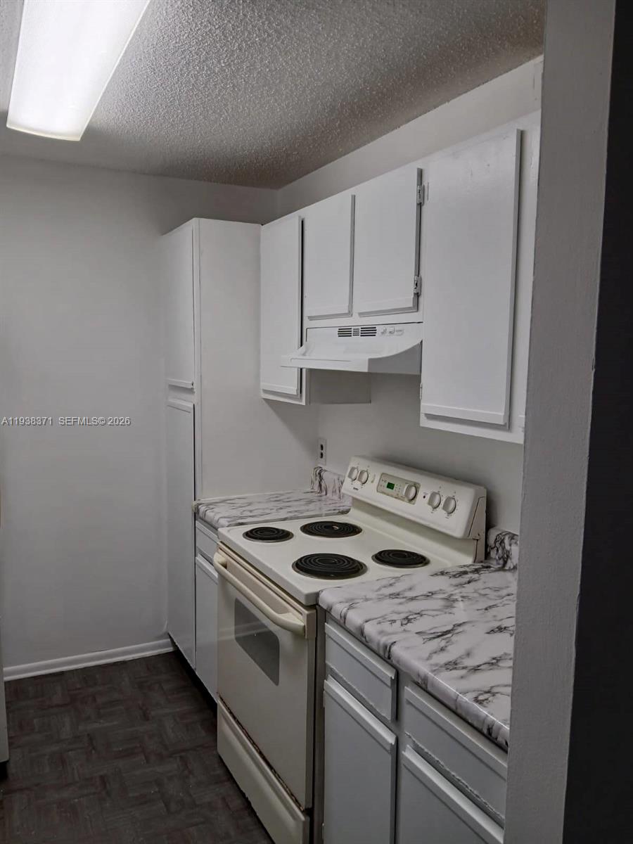 4521 West McNab Road, Unit 21 Pompano Beach, FL 33069 - Photo 6 of 18 a kitchen with granite countertop white cabinets and white appliances