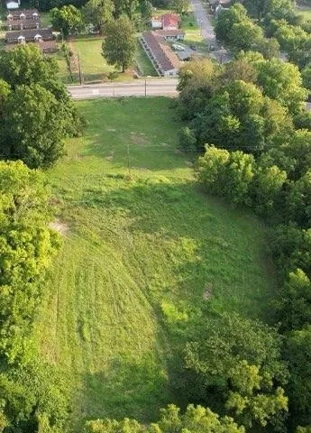 a view of a green field with wooden fence