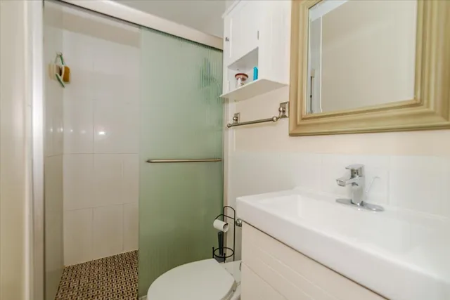 a bathroom with a sink a toilet and shower