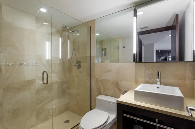 a bathroom with a sink toilet a mirror and shower