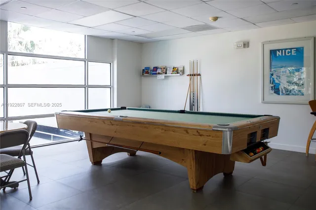 a room with furniture pool table and windows