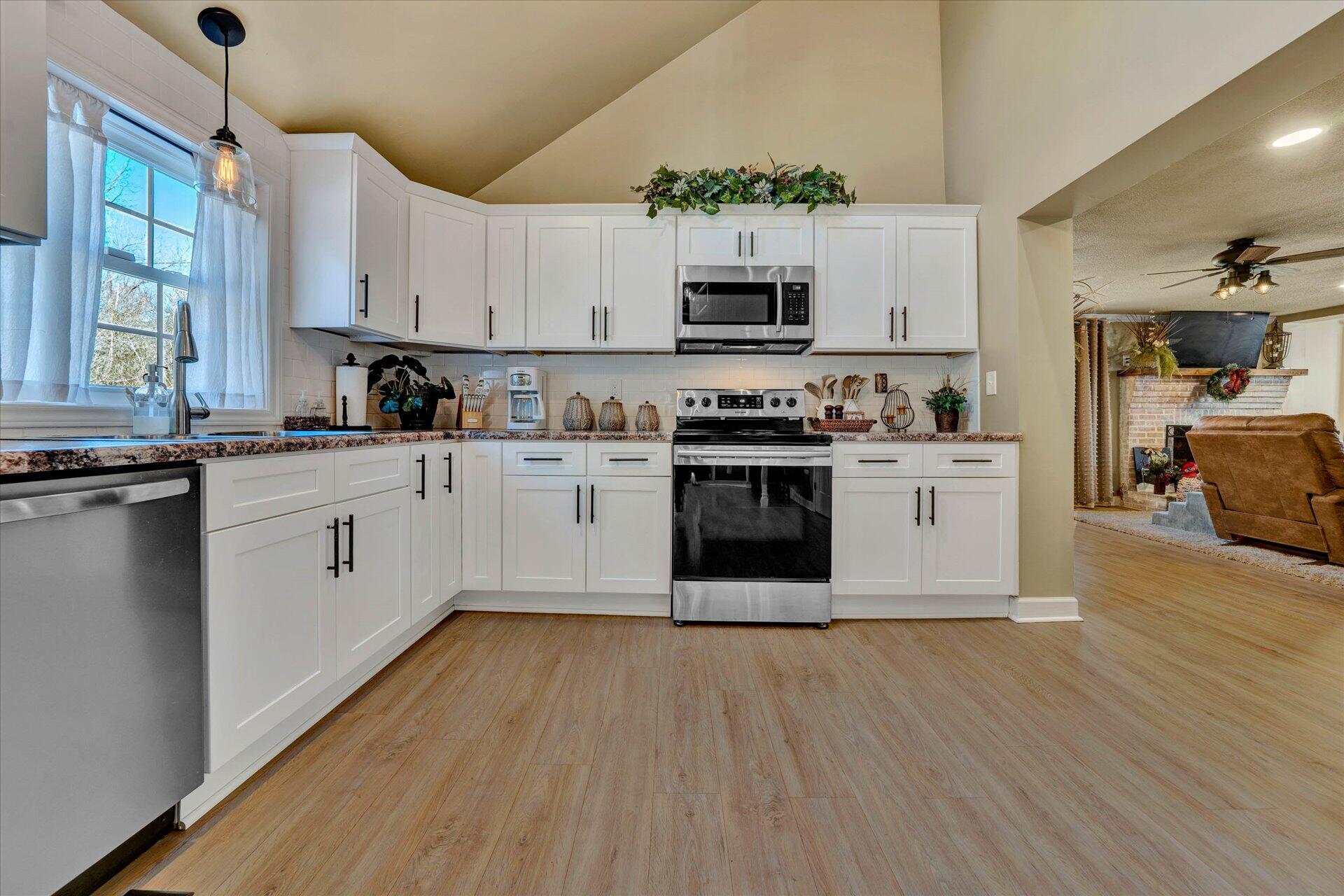 110 Nursery Road Boones Mill, VA 24065 - Photo 15 of 33 a kitchen with stainless steel appliances a white stove top oven cabinets and a wooden floor