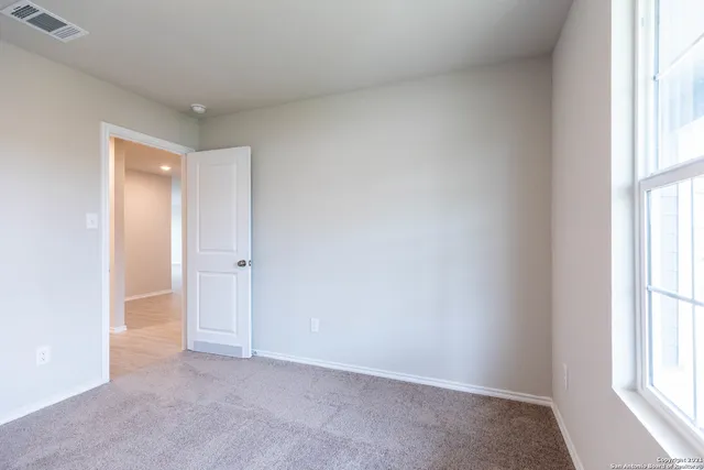 an empty room with windows and closet