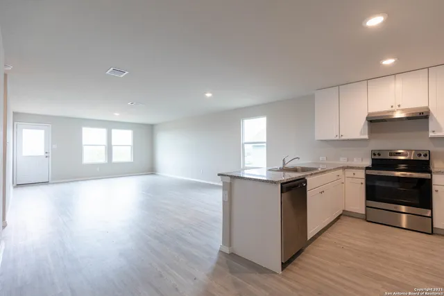 a kitchen with granite countertop a stove and cabinets