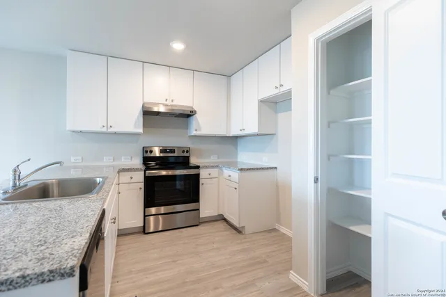 a kitchen with a sink cabinets and a window