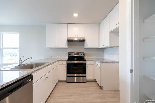 a kitchen with a sink stove and cabinets