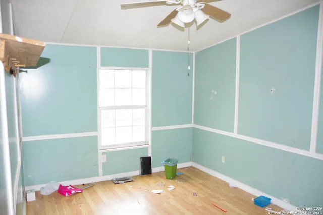 a bedroom with a bed and a chandelier fan