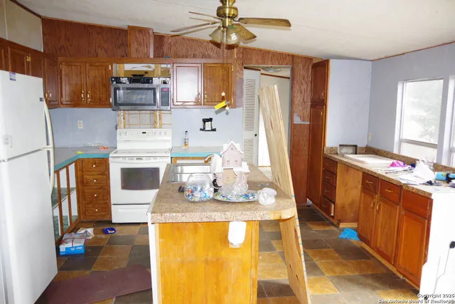 a kitchen with stainless steel appliances kitchen island granite countertop a refrigerator and a stove