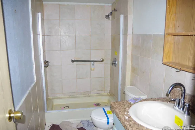 a bathroom with a granite countertop sink toilet and shower