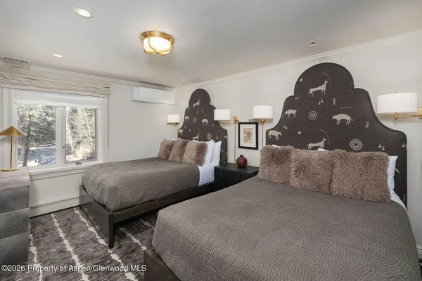 a bedroom with two beds and a large window