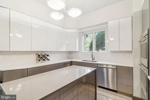a kitchen with a sink a counter top space cabinets and stainless steel appliances