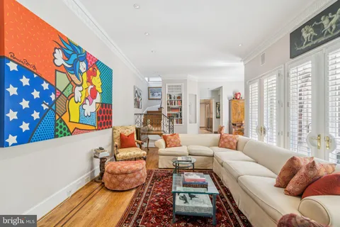 a living room with furniture and a large window with rug