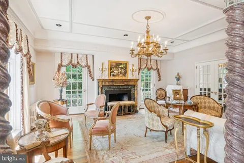 a view of a livingroom with furniture a chandelier and wooden floor