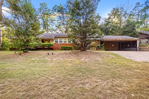 a view of a house with a yard and tree