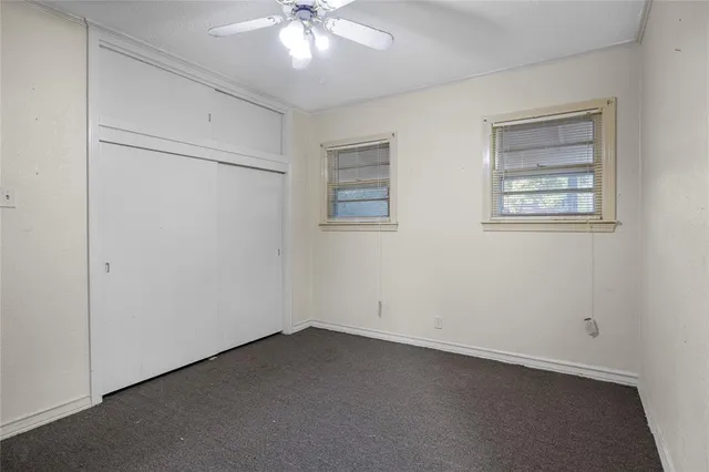 an empty room with a chandelier fan