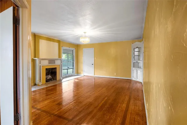 a view of an empty room with a fireplace and a window