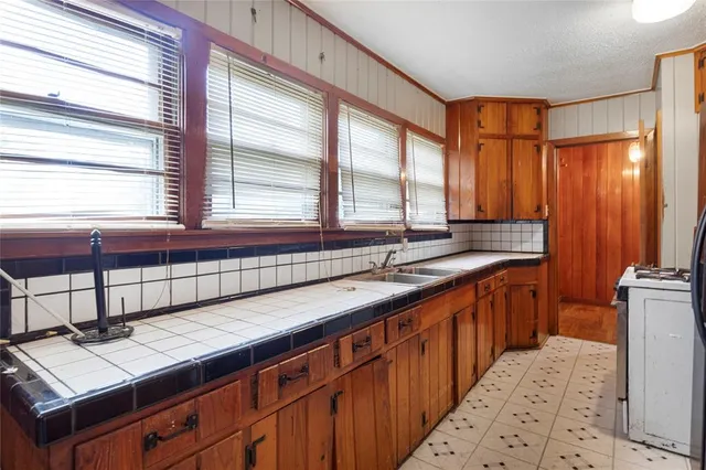a kitchen with stainless steel appliances a sink stove and cabinets