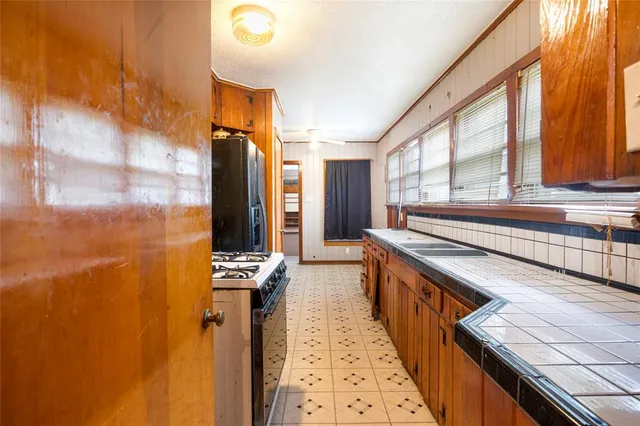 a view of a kitchen with stainless steel appliances granite countertop a sink and cabinets