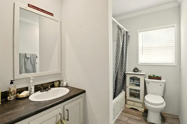 a bathroom with a granite countertop sink toilet and mirror