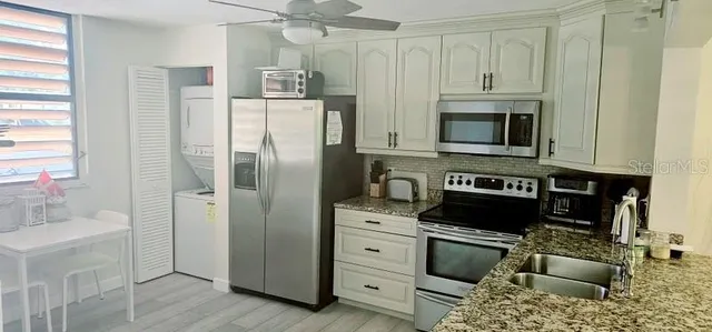 a kitchen with cabinets stainless steel appliances and a window