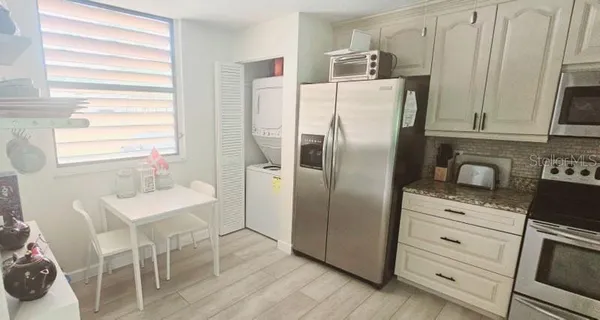 a kitchen with stainless steel appliances a refrigerator sink and wooden floor