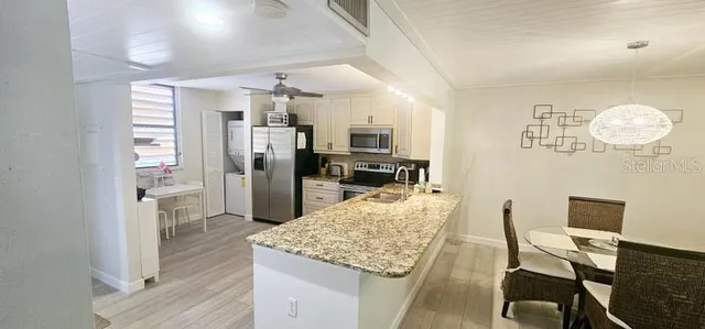 a kitchen with refrigerator and chairs