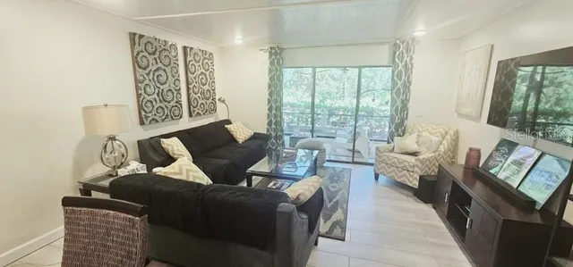 a living room with furniture and a floor to ceiling window