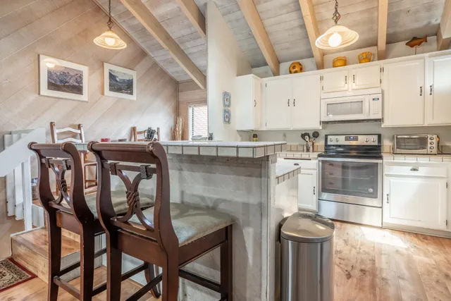 a kitchen with granite countertop a table chairs stove and cabinets