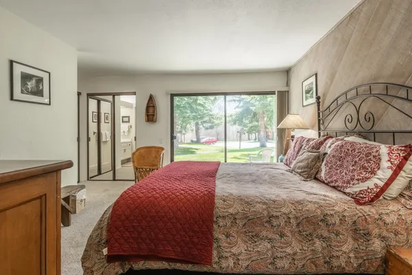 a bedroom with a large bed and wooden floor
