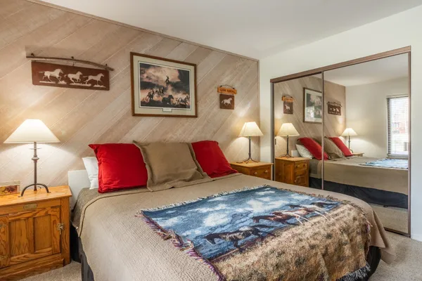 a bedroom with a large bed and a chandelier