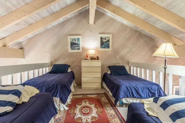 a bedroom with two beds and a lamp